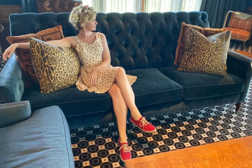 a woman sitting on a couch dressed in the old money aesthetic