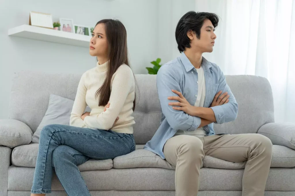 a guy and girl on a couch, fighting