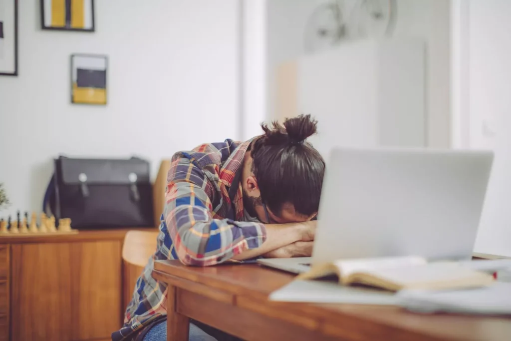a man facing burnout with his head down on his desk