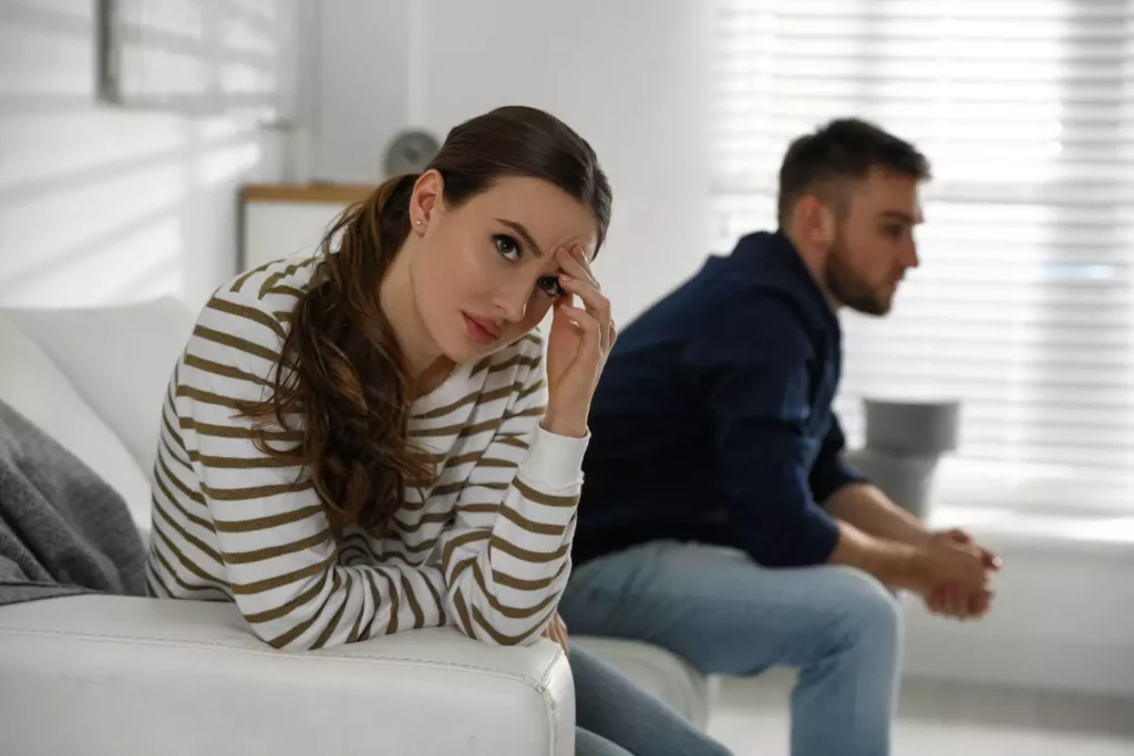 Couple sitting on a couch frustrated, dealing with relational issues