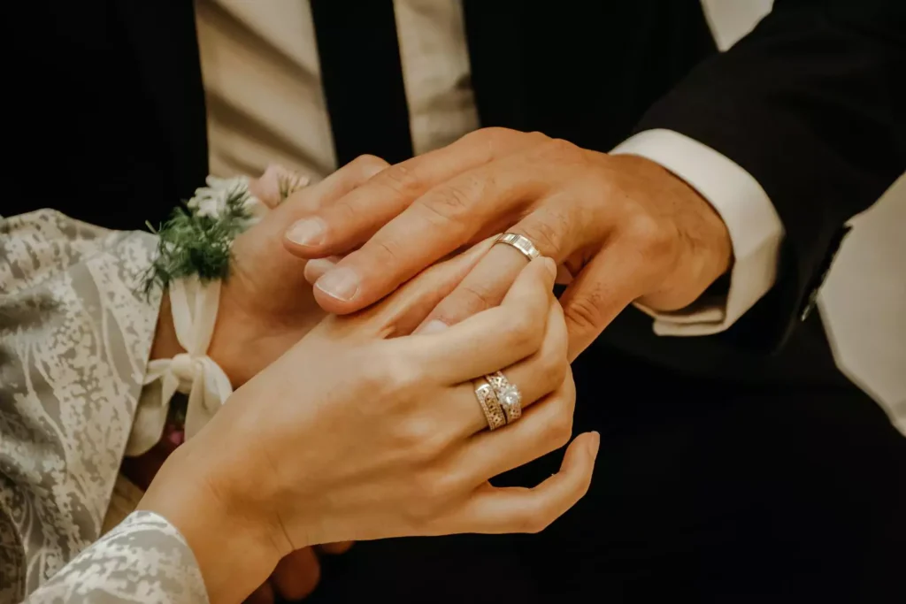 bride putting a ring on the groom's finger - why get married?