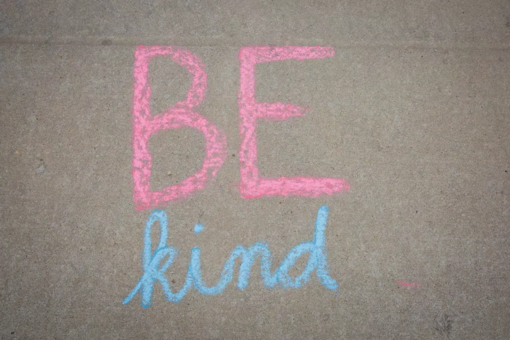 chalk writing on the sidewalk that says be kind. Acts of kindness.