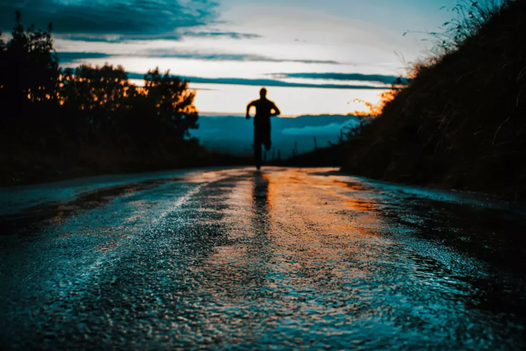 a man running down a street at sunset. Flee sin and pursue righteousness.