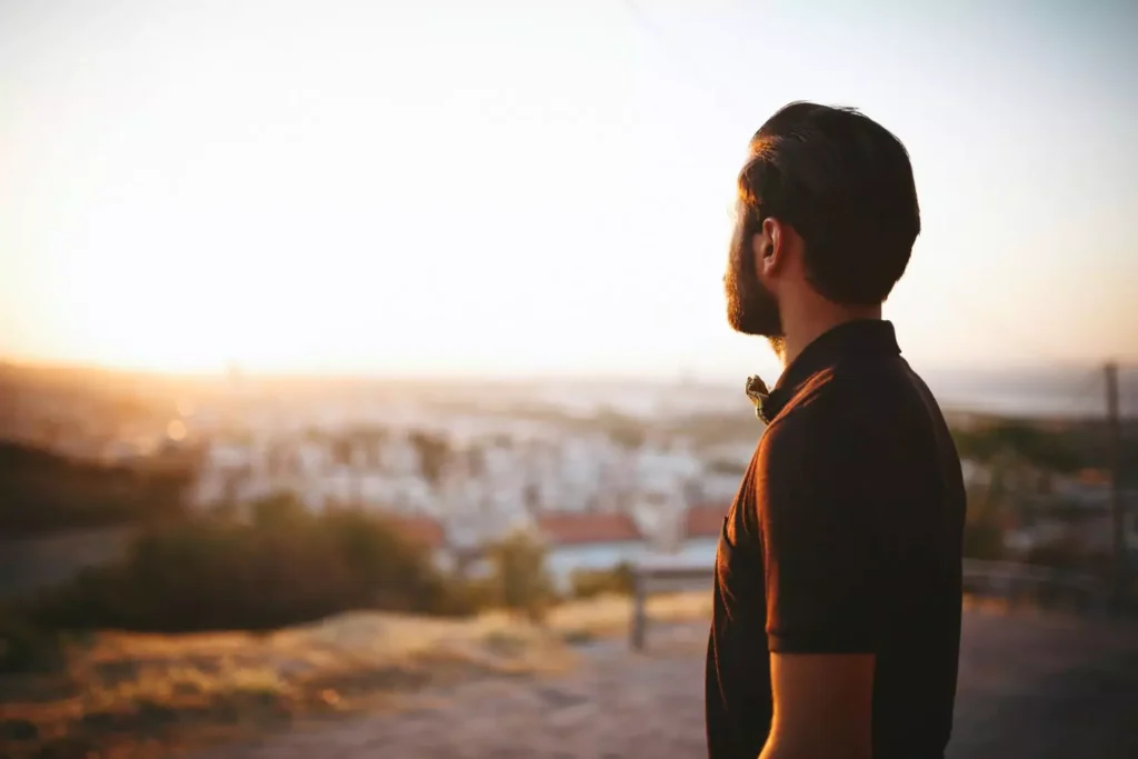 a young man looking at a sunset thinking about Jesus in His 20s