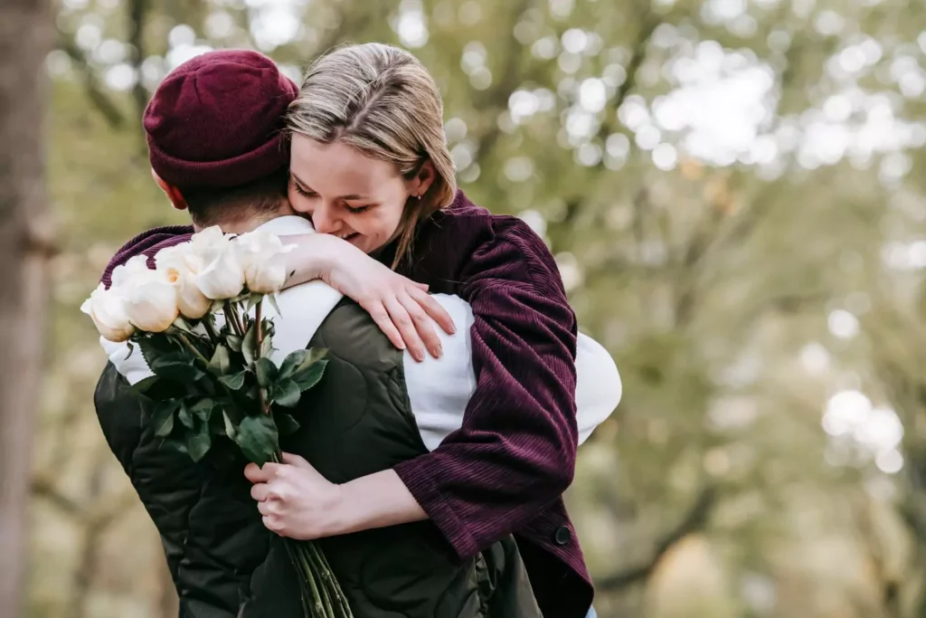 girlfriend holding flowers, hugging boyfriend. Things every girlfriend needs.