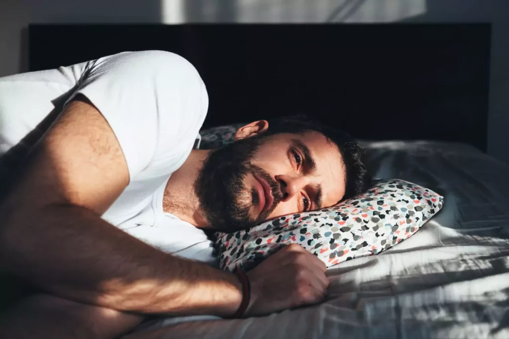 Man laying on bed grieving