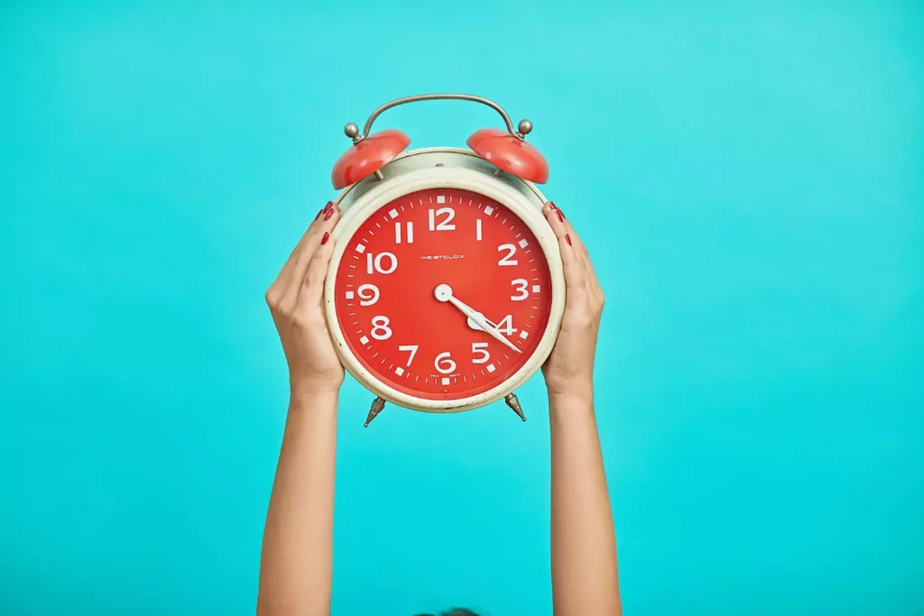 person holding a clock in the air, taming my time