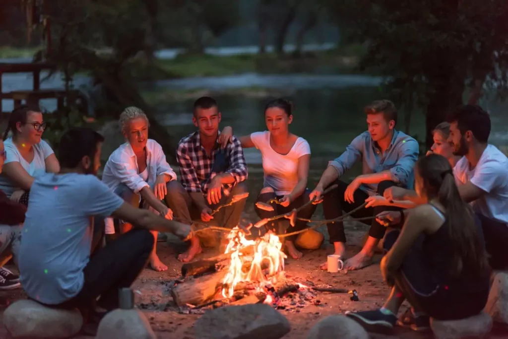 Friends around a campfire. Date someone from your friend group.