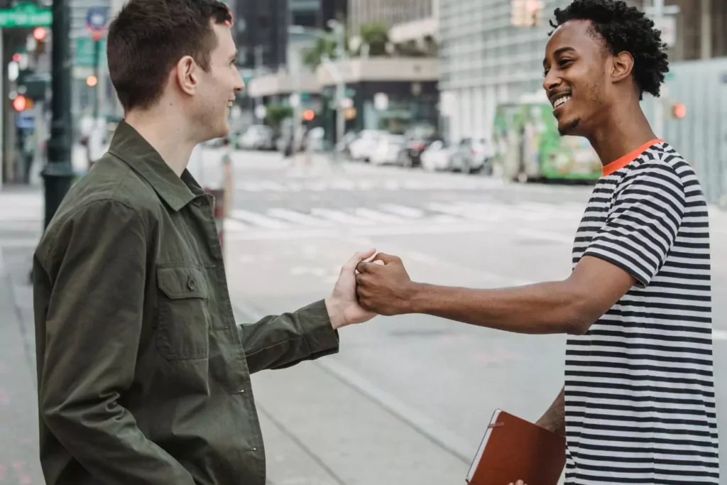 Two guy friends fist bumping