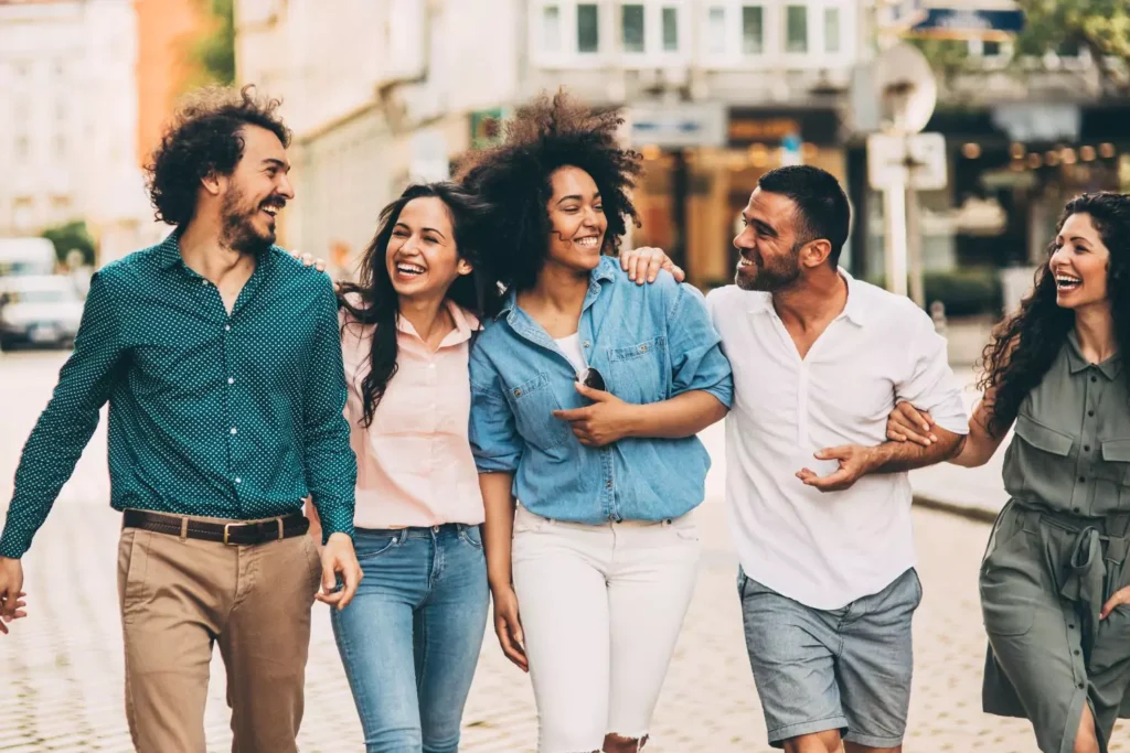 a group of friends walking together and smiling. In-person friendship