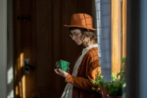 a woman in a hat holding a coffee cup - is Gen Z the most pessimistic generation?