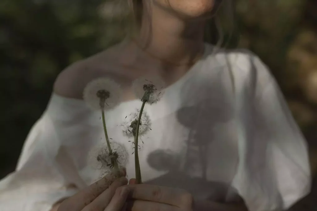 a woman holding flowers, a symbol of femininity