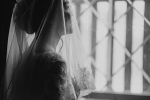 a bride, preparing to get married, looking out a window