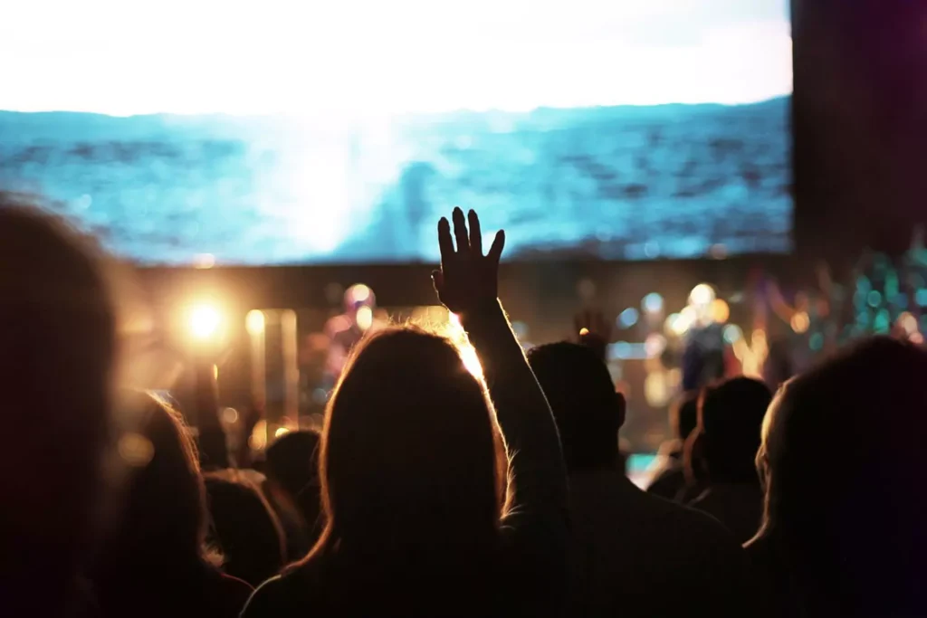 a woman at a spiritual experience lifting her hands in worship of the one true God