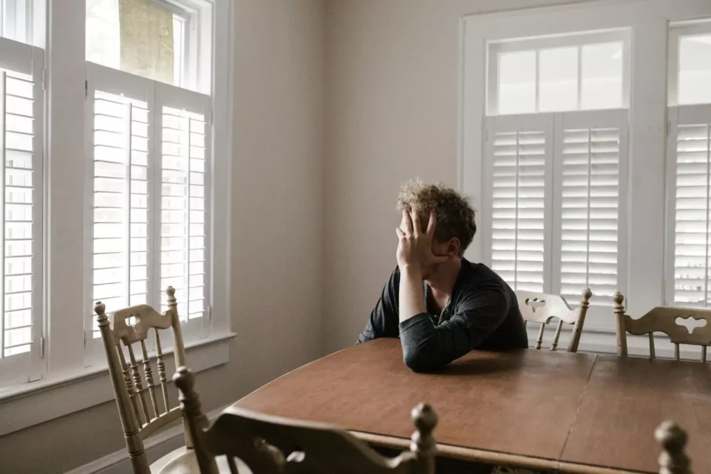 a man sitting at a table, hurt by his Christian friends