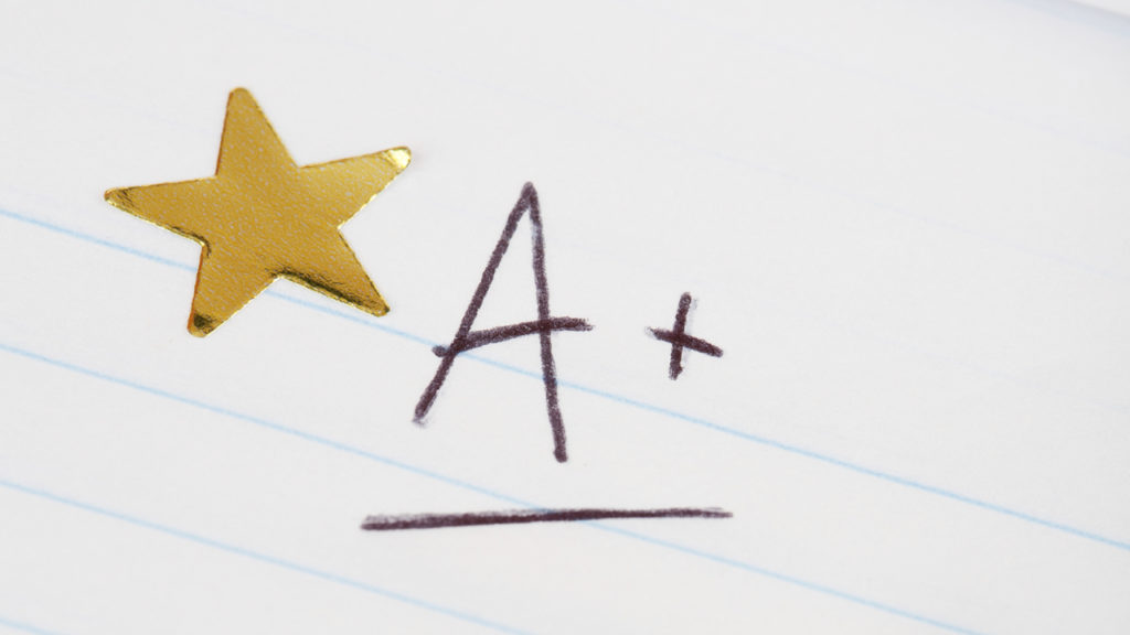 "A+" written on lined paper with a gold star sticker next to it