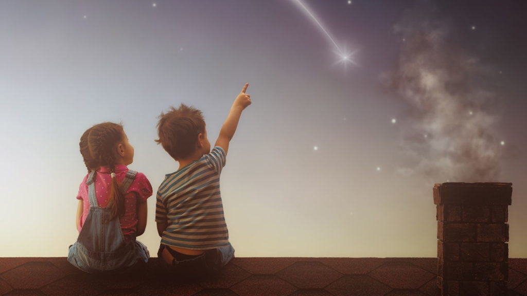 children sitting on roof looking at shooting star