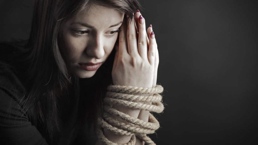 woman with hands bound together by rope