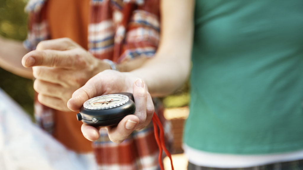 couple holding a compass and a map