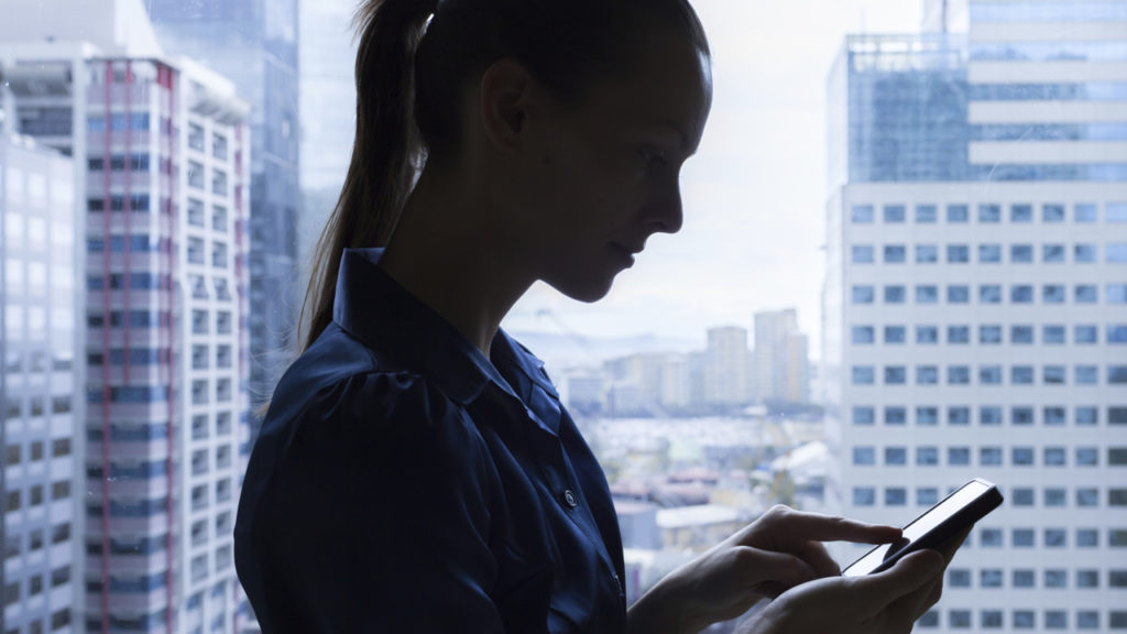 Woman looking at phone in a skyscraper