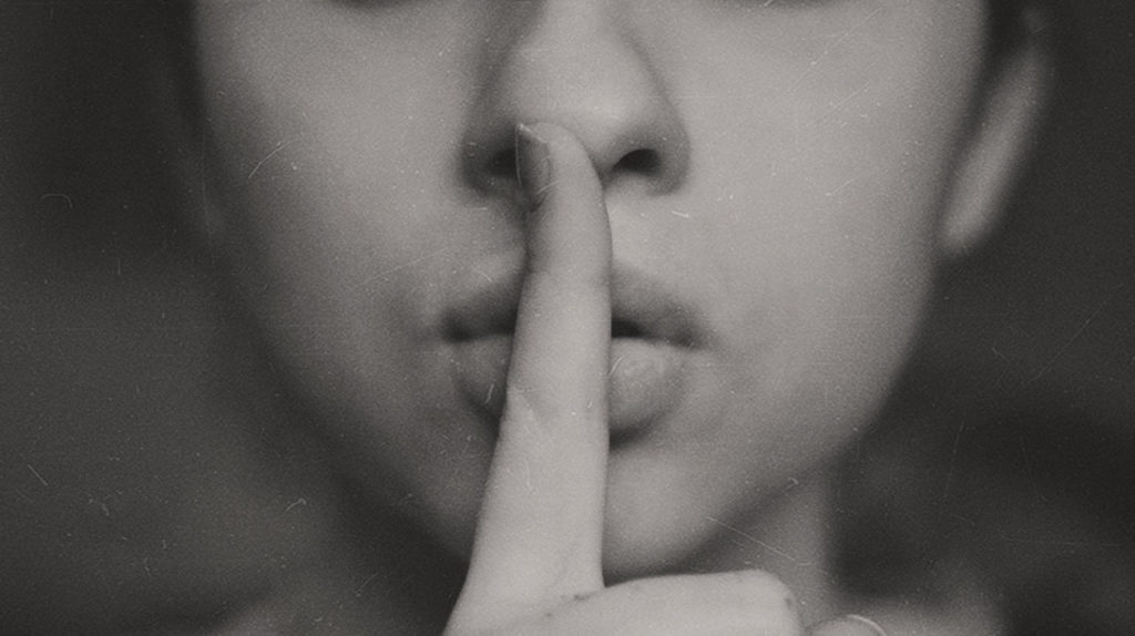 black and white person with finger to lips