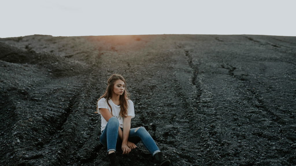 sad girl sitting in field